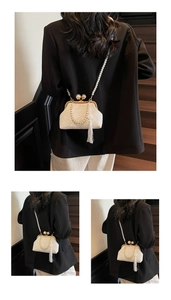 Detailed view of a white vintage kiss-lock bag featuring pearls and silk tassel