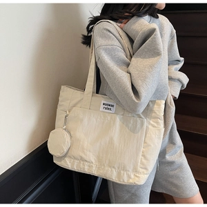 Detail of off-white large capacity tote bag with small matching round coin purse charm