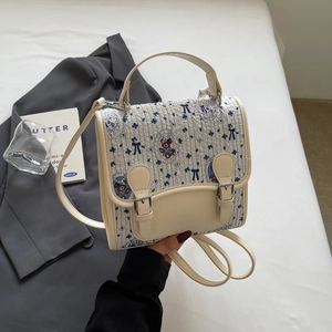 Détail d'un sac bandoulière crème avec motif ours mignon et boucles de fermeture