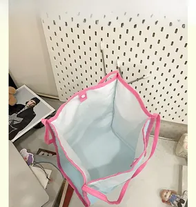 Top view of spacious interior of light blue canvas tote bag with pink straps