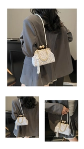 Close-up of white oriental embroidery bag with pearl strap and silk tassel detail