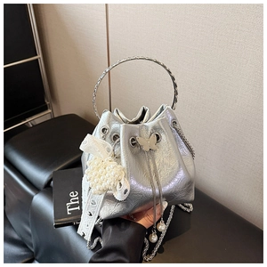 Détails du sac seau argenté métallisé avec fermoir papillon et ornements de perles