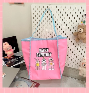 Detail of cute pink canvas tote bag featuring happy cartoon animals on a white pegboard