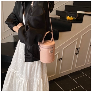 Secchiello rosa pallido alla moda con trama intrecciata indossato da modella in interni