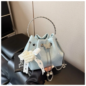 Détail du sac seau bleu clair avec décor de papillon argenté et dentelle de perles chic