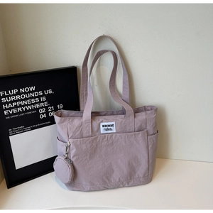 Detail view of pink tote bag with round mini coin purse and stylish letter label