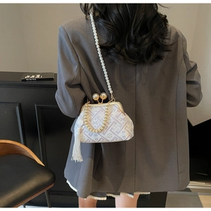 Detail view of vintage jacquard handbag with pearl straps and elegant white tassel decoration