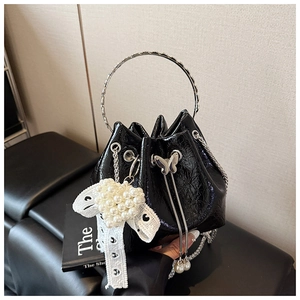 Détail du sac seau plissé noir avec breloque cœur en perles et poignée en métal