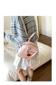 Détail du sac à dos rose chiot montrant le motif de pomme et la texture en cuir synthétique