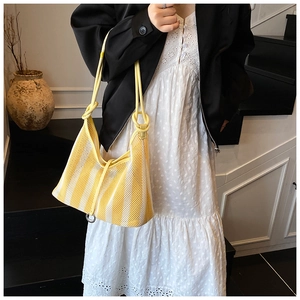 Vue détaillée du sac cabas en maille rayée avec fine bandoulière jaune et texture filet