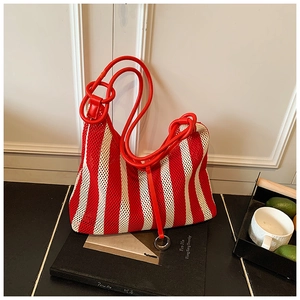 Détail du sac cabas en maille à rayures verticales rouges et blanches avec anneau métal