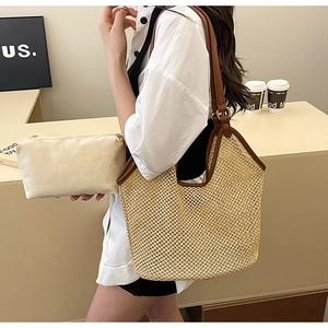 Detail of hollow woven straw tote with brown leather straps and canvas pouch insert