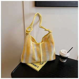 Gros plan du sac fourre-tout tissé à rayures jaunes et blanches avec bandoulière souple