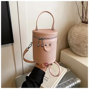 Dettaglio borsa a secchiello rosa con pelle trapuntata, trame intrecciate e zip in metallo argento