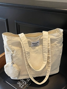 Chic cream nylon tote bag with small round coin purse pouch on a vintage chair
