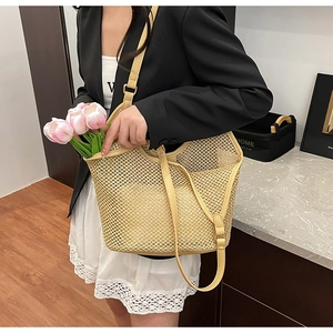 Detail of beige woven mesh tote bag with leather straps and inner pouch for summer beach