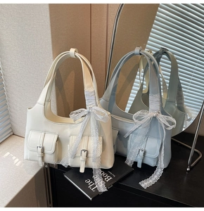 Dettaglio di borse tote color crema e blu con grandi fiocchi di pizzo e fibbie trendy