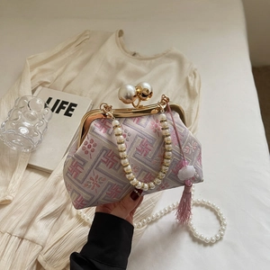 Detailed view of pink brocade cheongsam bag with pearl handle and soft silk tassel