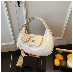 Détail du sac demi-lune crème en cuir froissé avec perles et pendentifs en dentelle