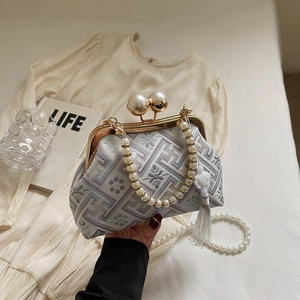 Detailed close-up of Chinese embroidery evening bag with pearl handle and silk tassel