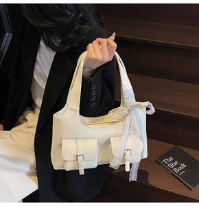 Dettaglio borsa tote bianca in similpelle con pizzo decorativo e fiocco a scacchi azzurri