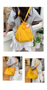 Détail du sac à dos en nylon jaune vif avec pendentif cœur et sangles réglables