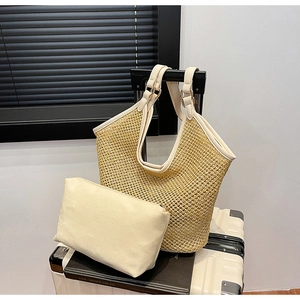 Close-up of woven straw tote bag with cream canvas pouch and leather handle details