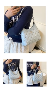 Close-up of light blue quilted shoulder bag with star logo and silver rivet details