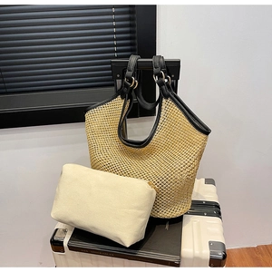 Close-up of woven mesh straw tote bag with black leather handle and canvas inner pouch