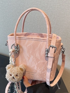 Pink marbled bucket bag with plush bear charm and silver hardware shown in full view
