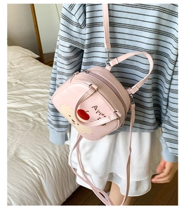 Mini sac rose avec motif chiot et pomme montrant les fermetures éclair et la poignée