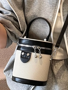 Moderna borsa a secchiello cilindrica in tela bianca e pelle nera con zip argentata