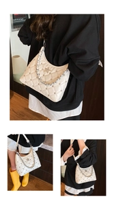 Detail of white quilted chain bag with silver rivets and metal star decorations