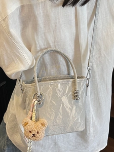 Chic light gray pleated bucket bag with plush bear charm and metallic ball detail