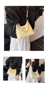 Detail of beige quilted hobo bag featuring silver studs and a glittery star emblem