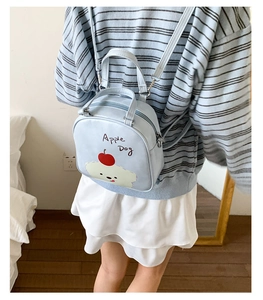 Détail d'un sac à dos Apple Dog bleu clair porté sur le dos pour montrer la taille