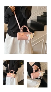 Borsa a cilindro rosa mostrata a tracolla e a mano con fiocco in pizzo e cuore di perle