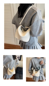 Close-up of white litchi pattern leather bucket bag with magnetic buckle and shoulder strap