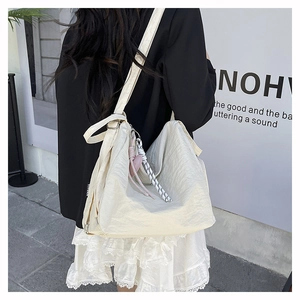 Détail du grand sac fourre-tout en nylon blanc cassé avec breloque cœur porté