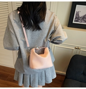 Pink lychee texture crossbody bag shown on a model in a cozy indoor setting
