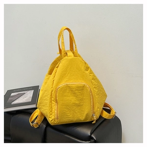 Détail d'un sac à dos géométrique en nylon jaune vif avec fermeture éclair incurvée