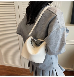 Detailed back view of a white litchi pattern leather crossbody bag shown on a model