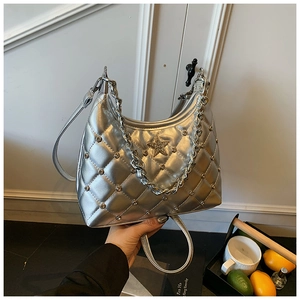 Detail of silver quilted handbag featuring rhinestone star logo and metal chain strap
