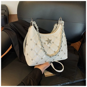Close-up of white quilted bag with silver star logo, metal studs and chain strap
