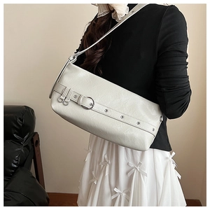 Close-up of white PU leather underarm bag featuring decorative belt buckle and metal eyelets