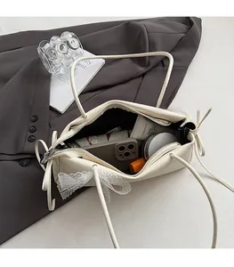 Vue détaillée d'un sac crème montrant l'intérieur spacieux et le détail du nœud