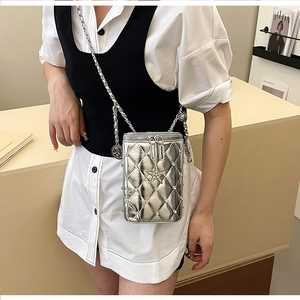 Silver quilted crossbody phone bag with star charm and metal chain strap on model