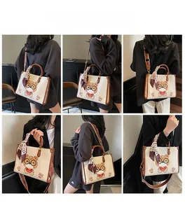 Detail view of cream tote bag with cat print, leopard scarf, and wide strap on model
