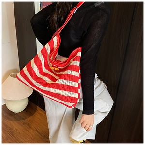 Detail view of woven red and white striped tote bag with a natural wooden horn button closure