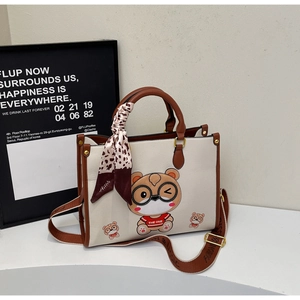 Detail of a contrast color tote bag featuring a cute cartoon bear and leopard scarf